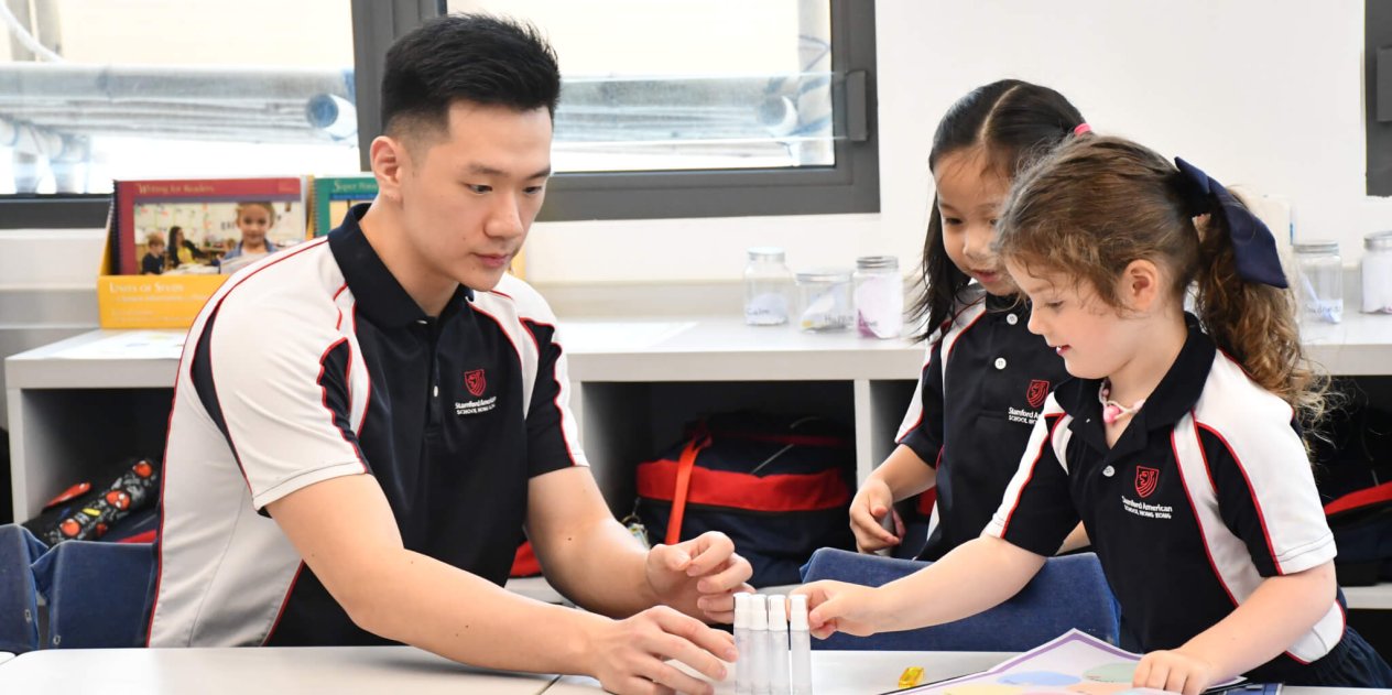 teacher helping students with experiment