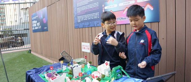 DSC04634 (2) (1) two young students showing their STEAM creation