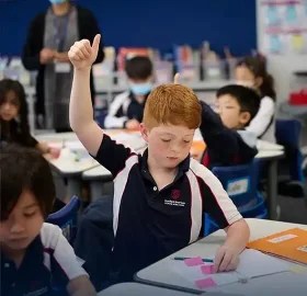 Stamford Elementary student raising his hand during class