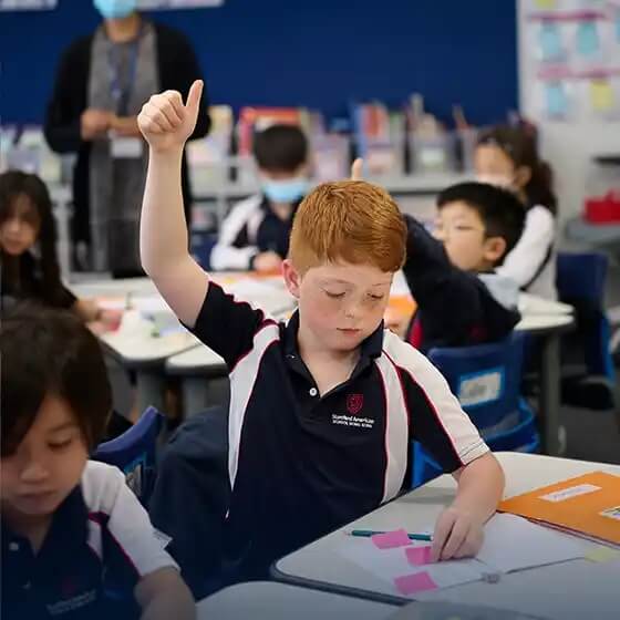Stamford Elementary student raising his hand during class