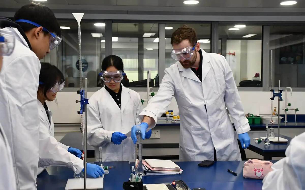 High school student doing experiment in science lab